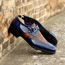 Load image into Gallery viewer, A pair of ADORSI Blue Patent & Brown Croco Single Monk Golf Shoes leaning against a brick wall.