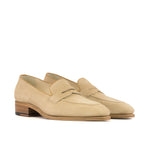 A pair of beige camel suede penny loafers with cognac box calf piping and a chisel toe.