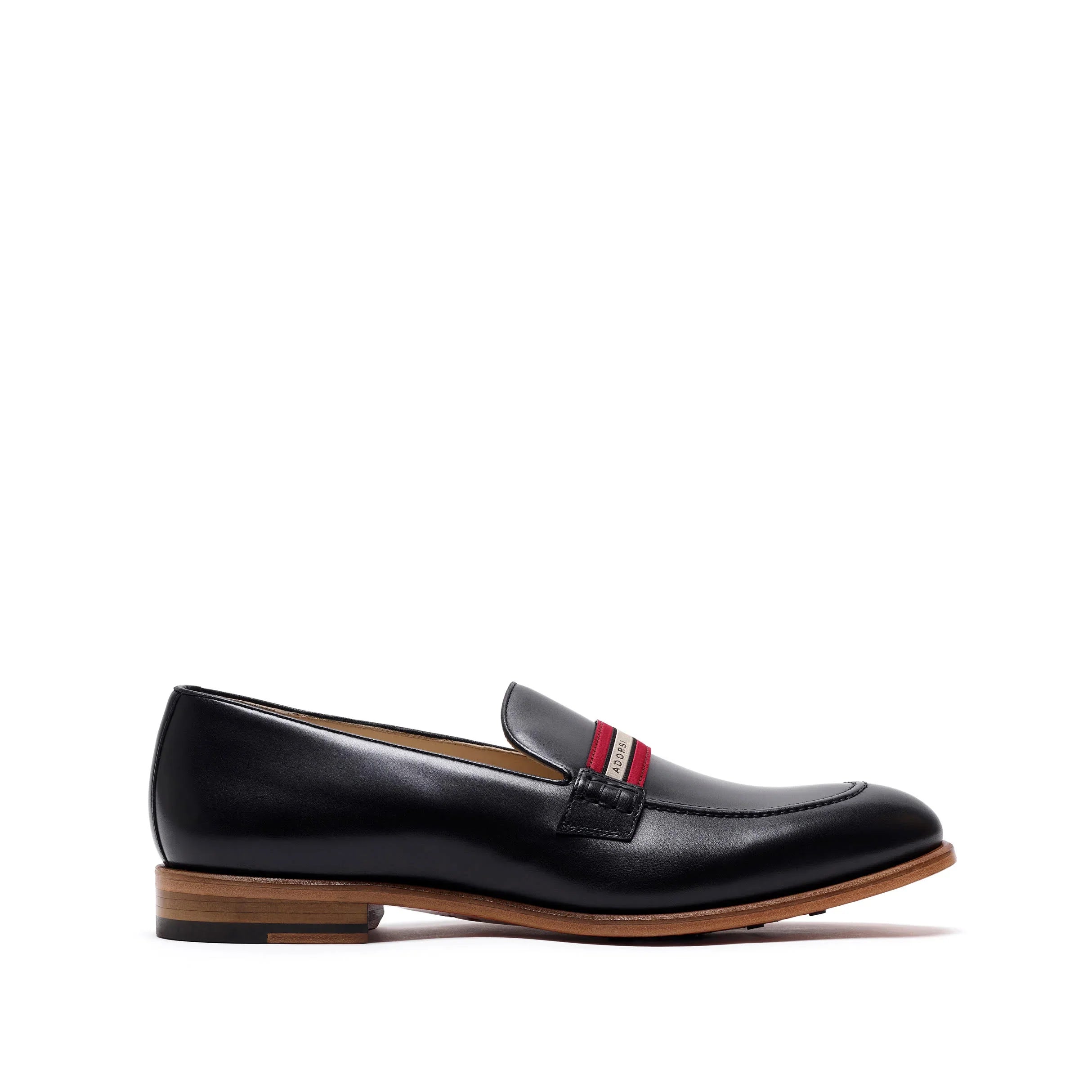 Side profile of a chic black calf leather loafer featuring a web stripe accent and a natural leather sole, presented against a pure white backdrop.