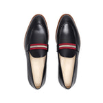 Top-down view of luxurious black calf loafers with a web stripe band, highlighting the meticulous stitching and craftsmanship on a white surface.