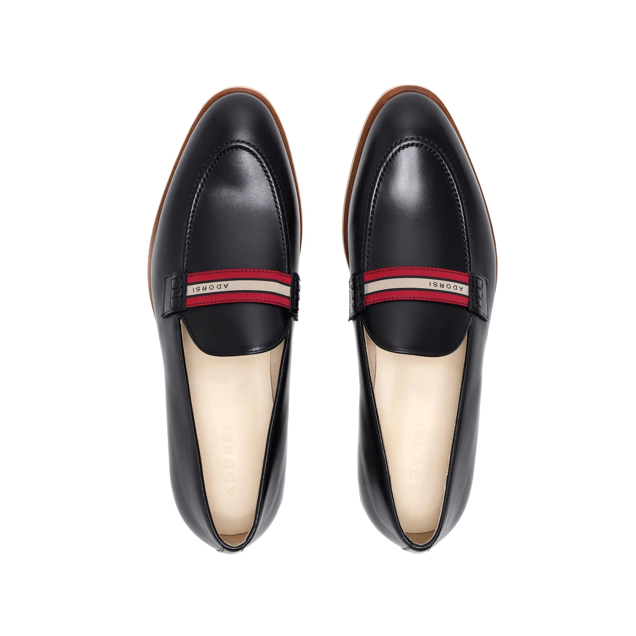 Top-down view of luxurious black calf loafers with a web stripe band, highlighting the meticulous stitching and craftsmanship on a white surface.
