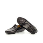 An image displaying the unique pebbled sole of a black nappa leather penny driving loafer, highlighting the rubber nubs for grip and comfort.
