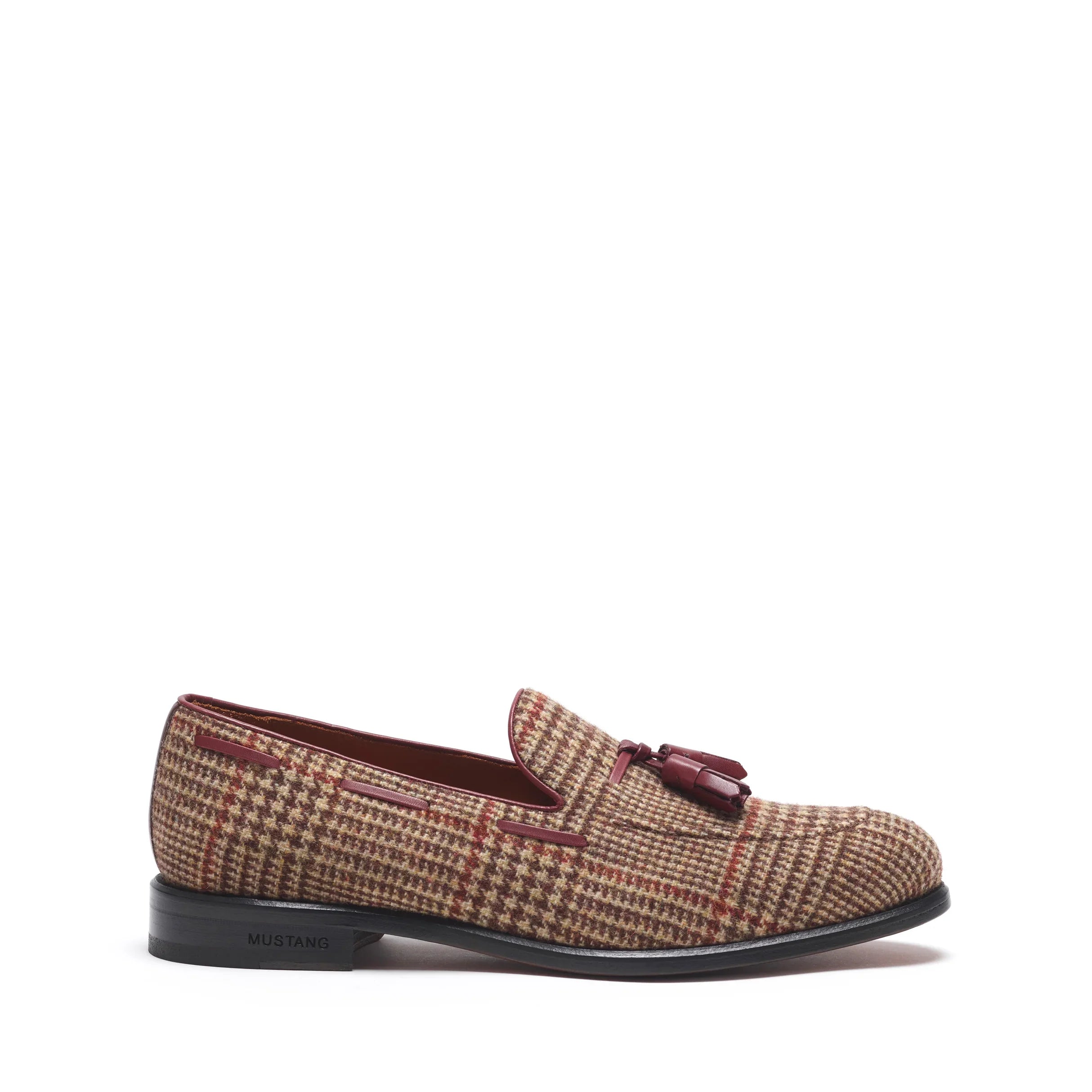 Side angle showcasing the sleek silhouette of brown tweed loafers with tassel accents and a low-profile black heel.