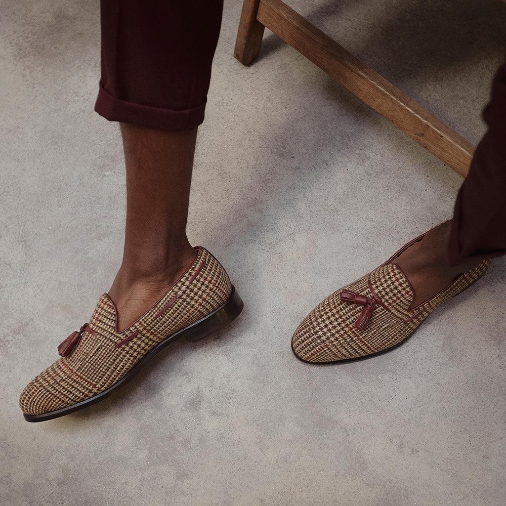 Lifestyle image featuring a person wearing brown tweed tassel loafers, perfectly paired with burgundy trousers for a smart-casual look.