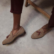 Load image into Gallery viewer, Lifestyle image featuring a person wearing brown tweed tassel loafers, perfectly paired with burgundy trousers for a smart-casual look.
