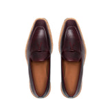 Top-down image of the loafers highlighting the grainy texture of the leather and the classic loafer bow on a white surface.
