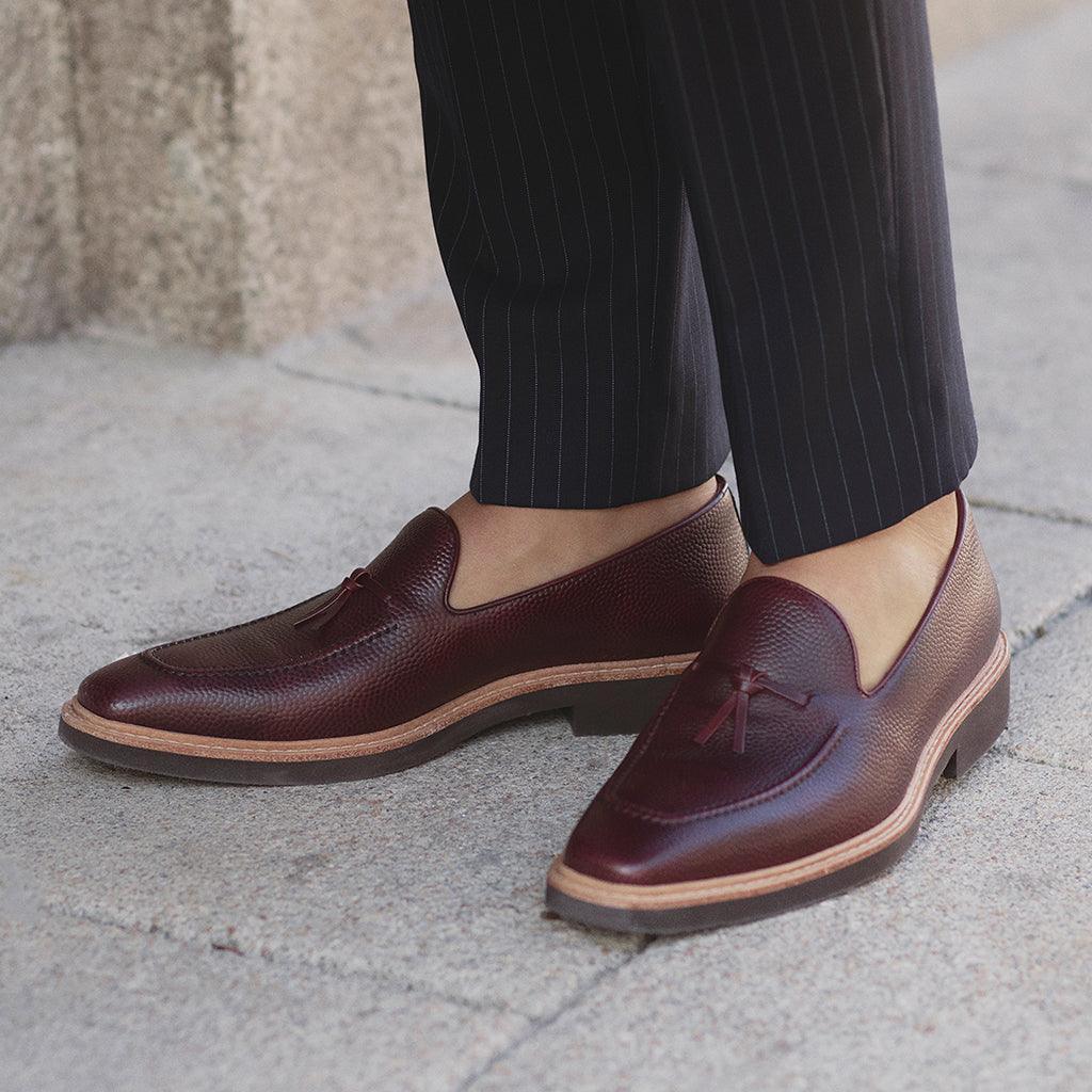 Stylish lifestyle shot of a person wearing the burgundy Belgian loafers, paired with pinstripe trousers for a classic and professional look.