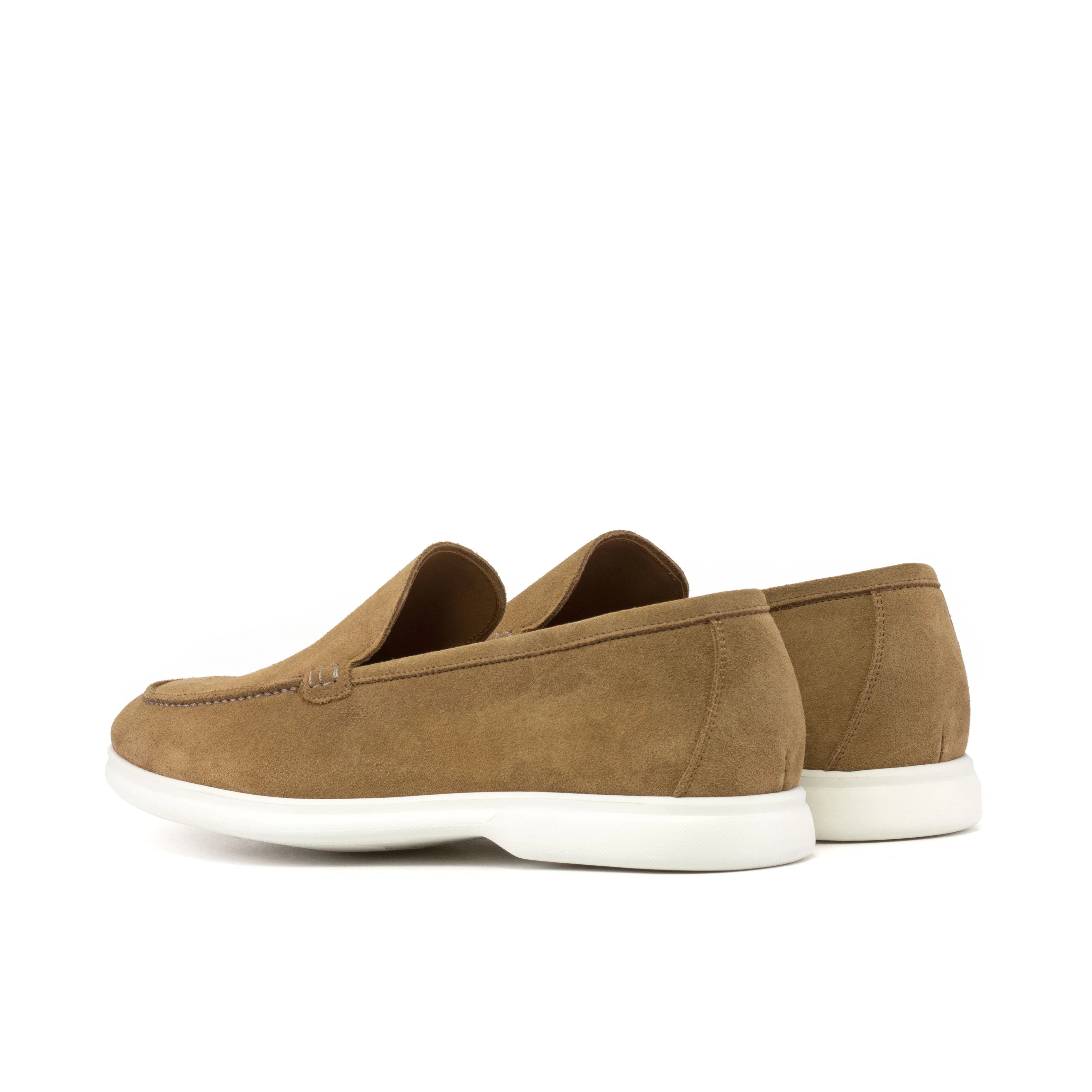 Profile view of camel suede casual loafers showing the side stitching details and the soft curves of the design, against a clean white backdrop.