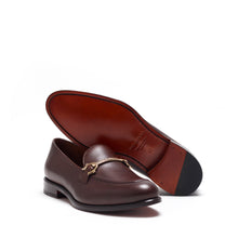Load image into Gallery viewer, A single dark brown calf leather horsebit loafer angled to show the cognac leather sole, with its luxurious finish and understated elegance.
