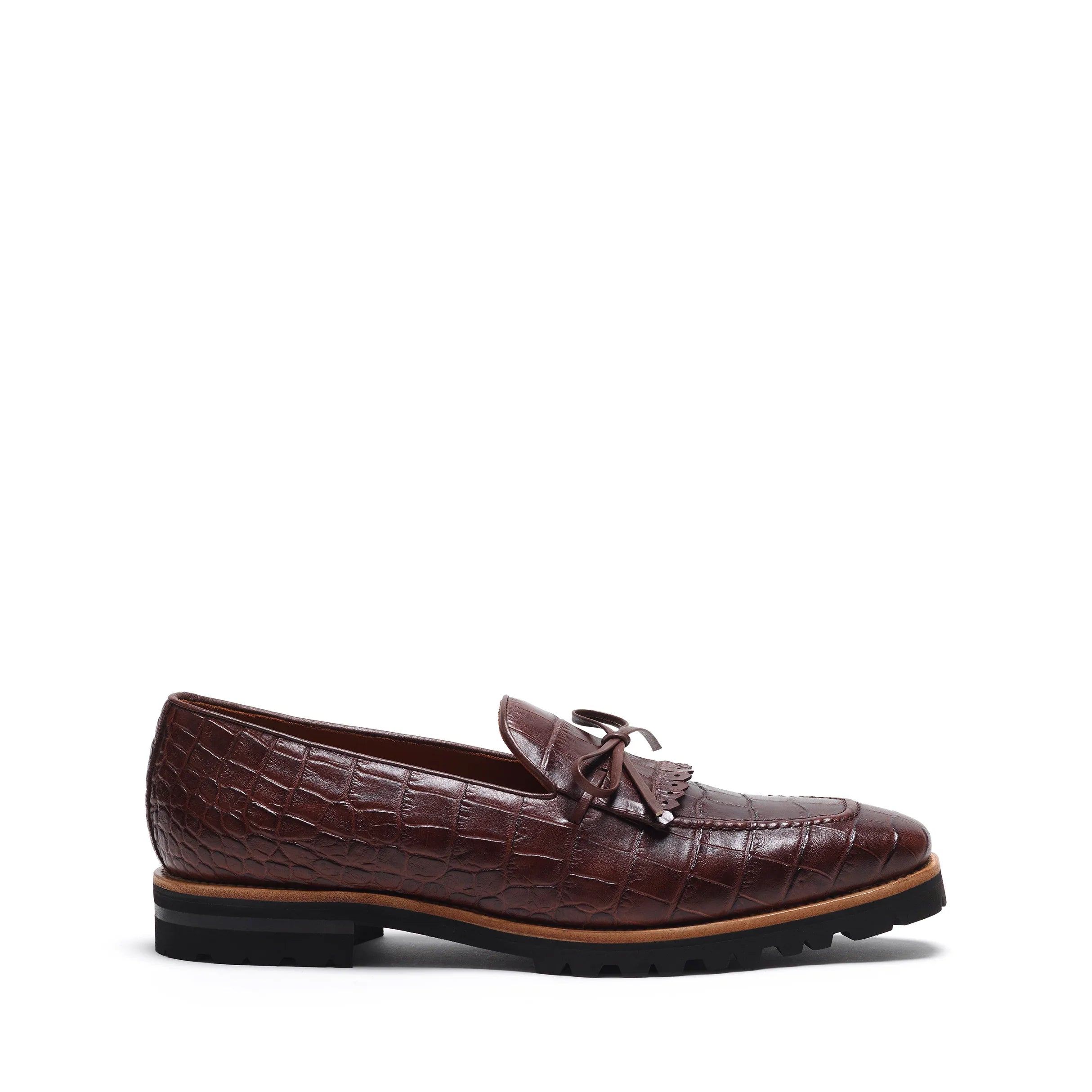 Side profile of a dark brown croco-textured kiltie loafer with an elegant lace-up design and black rugged sole, displayed on a white backdrop.