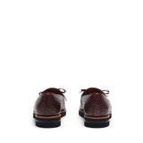 Rear angle showcasing the back detail of dark brown croco-textured kiltie loafers, set against a white environment.