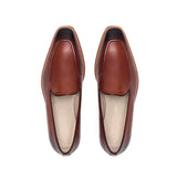 Top view of burnished medium brown calf plain loafers showing the Squared toe and flawless finish, presented on a white surface.