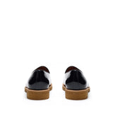 Back view of glossy patent black belgian loafers highlighting the sturdy heel construction with a tan sole, contrast stitching, and a polished finish.