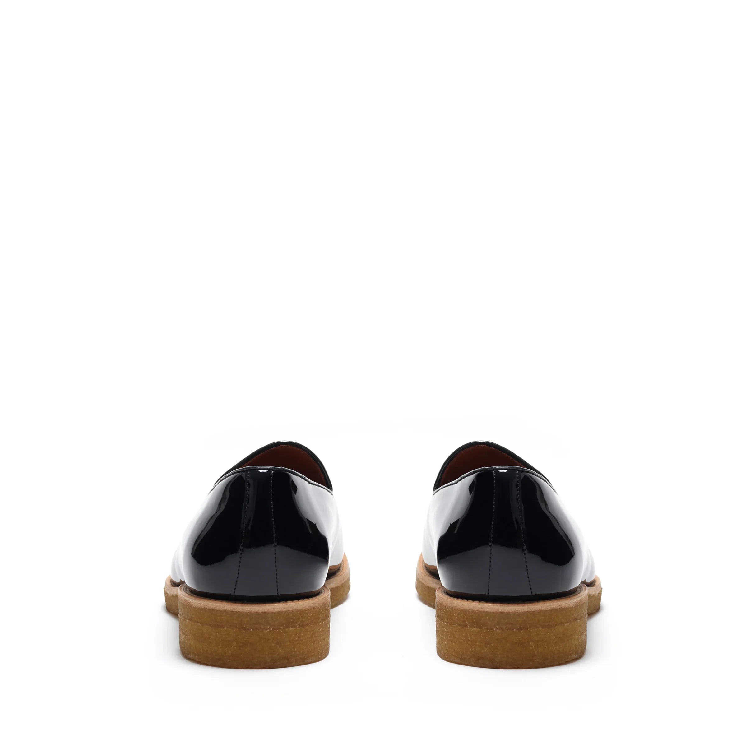 Back view of glossy patent black belgian loafers highlighting the sturdy heel construction with a tan sole, contrast stitching, and a polished finish.