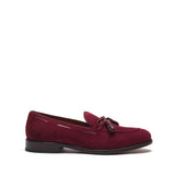 Side view of a wine suede laced tassel loafer highlighting the low heel and the intricate stitching around the vamp.