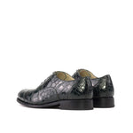 Pair of green crocodile-patterned shoes on a white background
