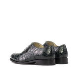 Pair of green crocodile-patterned shoes on a white background