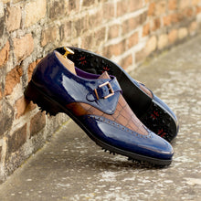 Load image into Gallery viewer, A pair of ADORSI Blue Patent &amp; Brown Croco Single Monk Golf Shoes leaning against a brick wall.
