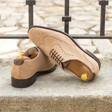 Load image into Gallery viewer, A pair of ADORSI beige suede wholecut shoes sitting on a stone wall.
